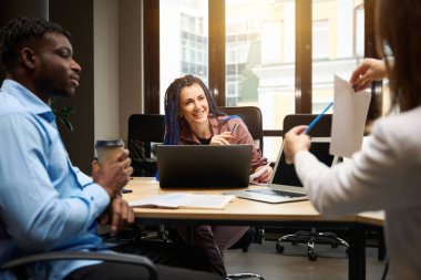 Öğrencilere gülen modern öğretmenler, teneffüste öğretmenler odasında oturur, arkadaş canlısı takım dizüstü bilgisayarlar üzerinde çalışır, kahve içer, fikirleri paylaşır ve tartışırlar.