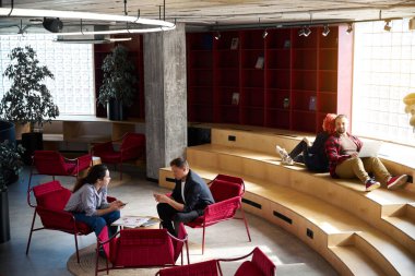 Birlikte çalışma alanındaki geniş alana bakın, ücretsiz kablosuz ağ, sandalye ve tabloların olduğu insanların okuyabileceği, çalışabileceği veya birbirleriyle iletişim kurabileceği bir yere