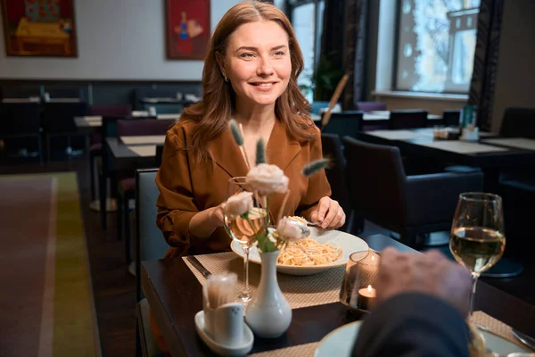 大人の笑顔の白人女性とホテルのレストランでパスタを食べる部分的な男性 ロマンチックな日付とイベントのコンセプト — ストック写真