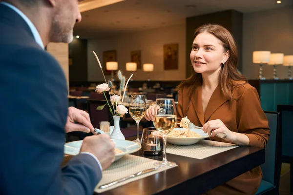 大人の幸せな白人女性とパスタを食べて ホテルのレストランでお互いを見ています ロマンチックな日付とイベントのコンセプト — ストック写真