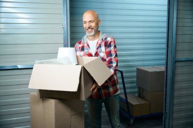 Yetişkin, gülümseyen kel adam bir kutu aldı.