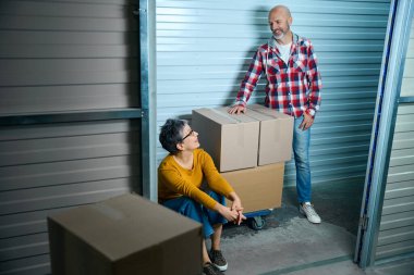 Bayan merdivenlerde oturur ve gülümseyen adama bakar.