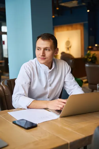 Man Keukenuniform Werkt Met Documenten Restaurantzaal Hij Gebruikt Een Laptop — Stockfoto