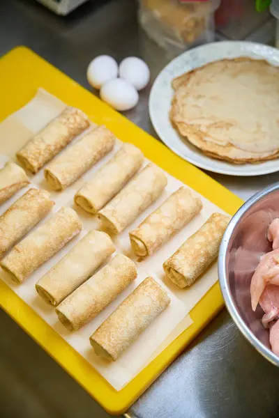 Pancakes with meat filling lie on a yellow cutting board, fresh, high-quality products are used in the preparation