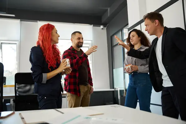 Male business analysts having fun and giving high five to each other finding common solution, female mangers drinking coffee and sincerely rejoicing to successful cooperation