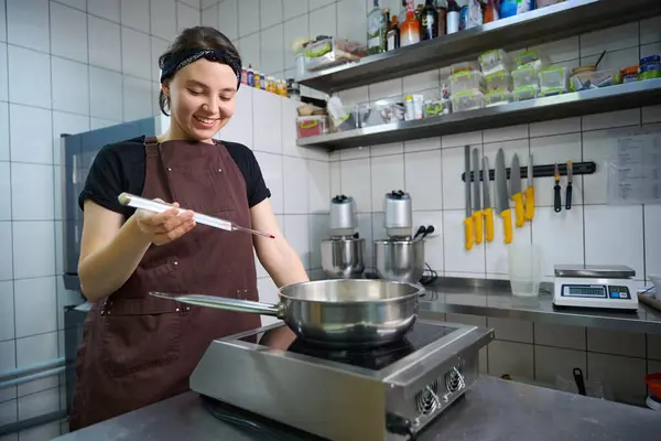 Cocinera Sonriente Sosteniendo Termómetro Sobre Una Cacerola Colocada Una Cocina — Foto de Stock