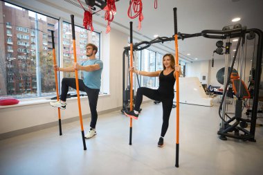 Sağlık merkezi istemcileri özel spor sopaları kullanarak denge egzersizleri yaparlar