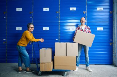 Kel bir adam ve kısa saçlı bir kadın depolamak için hücrenin girişine yakın.