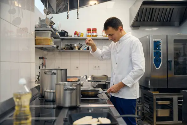 Man Uniform Bereidt Eten Een Restaurant Keuken Hij Gebruikt Specerijen — Stockfoto