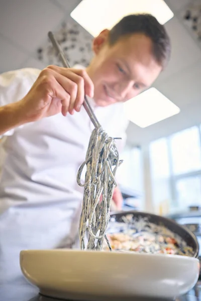 Cook Överför Spaghetti Sås Till Tallrik Från Stekpanna Han Arbetar — Stockfoto