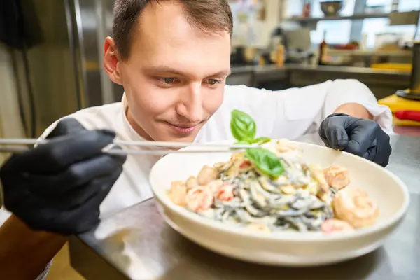 Man Versiert Spaghetti Saus Met Basilicum Bladeren Hij Werkt Beschermende — Stockfoto