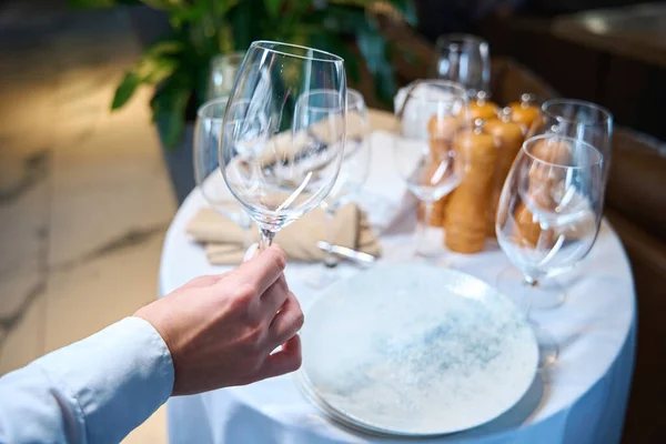 ウェイターは大きなガラスを手に持っていて レストランのホールにテーブルを置いている — ストック写真