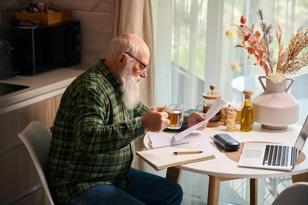 Пожилой Человек Работает Кухонным Столом Ноутбуке Столе Композиция Сушеных Цветов — стоковое фото