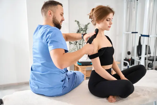 Employee Kinesitherapy Clinic Glues Black Tape Patients Shoulder Man Blue — Stock Photo, Image