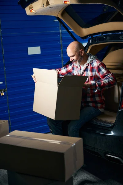 Adam, her şeyin katlandığı bir karton kutuya bakar.