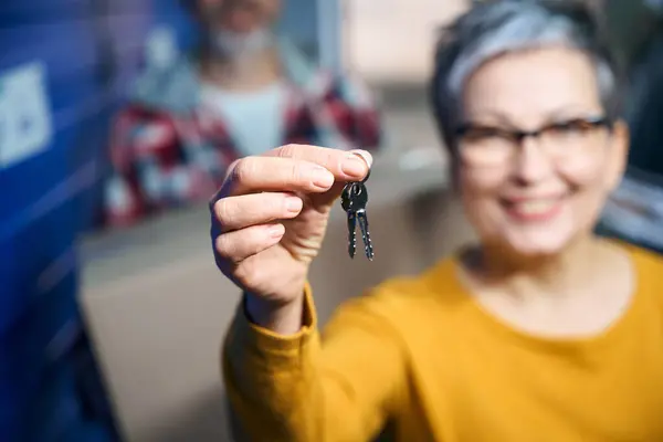 Keys to a luggage storage room in the hands of a woman with a short haircut