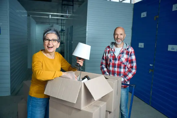 Smiling Woman Taking Lamp Out Shipping Box — Stock Photo, Image
