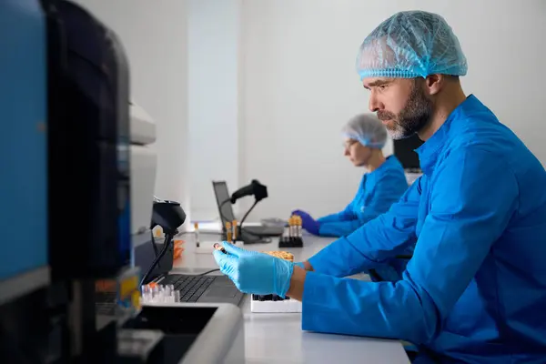 Laboratuvardaki Adam Kan Örnekleriyle Çalışıyor Meslektaşı Yakınlarda Çalışıyor — Stok fotoğraf