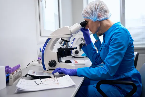 Inmunólogo Femenino Examina Material Biológico Bajo Microscopio Colega Trabaja Cerca —  Fotos de Stock