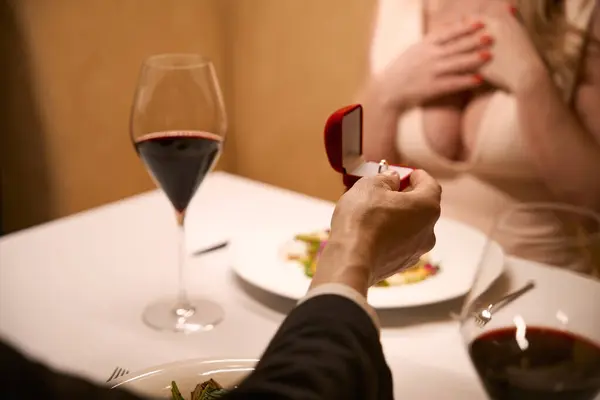 男性はレストランでロマンチックな夕食を持つカップル 小さな赤い箱で婚約指輪を与えます — ストック写真