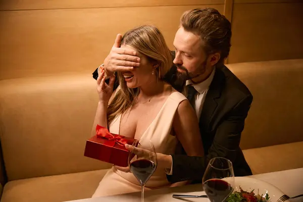 Surprise for a charming lady at a romantic dinner, gift in a red box