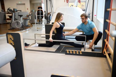 Eğitmen, özel bir cihaz kullanarak bir kadının ayrılmasına yardım eder.