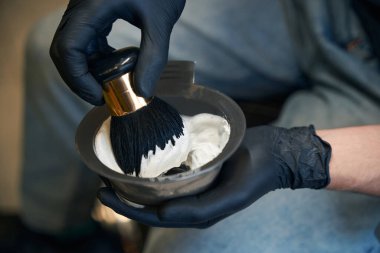 Elinde tıraş malzemeleri tutan tanınmamış bir berber.