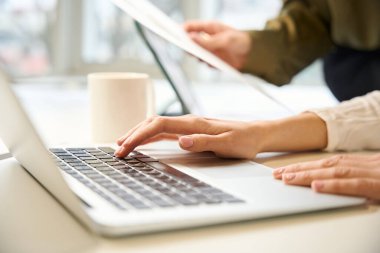 Tanımlanamayan giyim tasarımcısı ve asistanı ofis ortamındaki teknolojileri kullanarak birlikte çalışıyorlar.