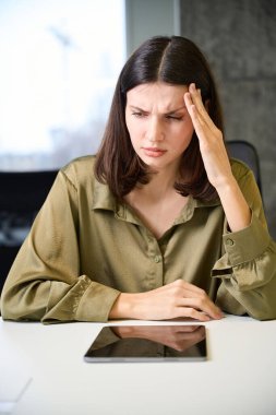 Sağlıksız giyim tasarımcısı ofiste çalışırken baş ağrısı çekiyor