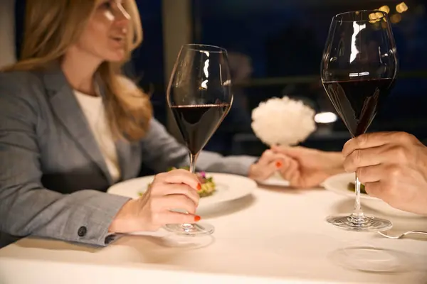 Couple has a nice conversation over dinner in a cozy restaurant, red wine is ordered