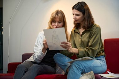 Birlikte çalışma ortamındaki moda profesyonelleri ofiste kıyafet tasarımı fikirlerini paylaşıyorlar