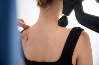 Fizyoterapist hastalara masaj yapıyor. Özel bir masaj aleti, rahat kıyafetler giyen bir kadın.