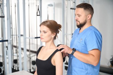 Fizyoterapist doktor hastalara masaj yapıyor. Özel bir masaj aleti ile. Rehabilitasyon merkezinde.