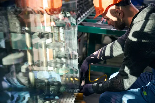 Specialist blows argon gas into a double-glazed window using high-tech equipment, a man wearing protective gloves