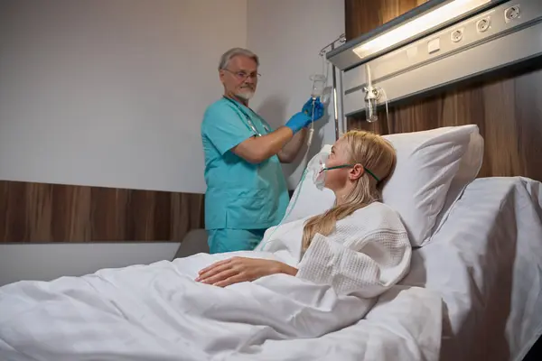 Pacjent Leżący Szpitalnym Łóżku Podczas Gdy Lekarz Podający Płynny Lek — Zdjęcie stockowe