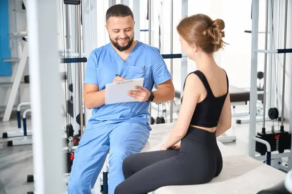 Physiothérapeute Instructeur Interroge Une Patiente Consultation Lieu Dans Salle Gym Photos De Stock Libres De Droits