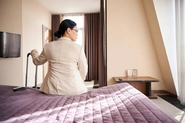 Back View Businesswoman Seated Edge Bed Her Suite While Leaning Stock Picture