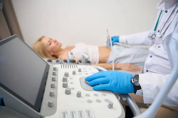 Nahaufnahme Des Ultraschallscanners Arzt Bewegt Schallwandler Auf Patientenbauch Und Führt lizenzfreie Stockbilder