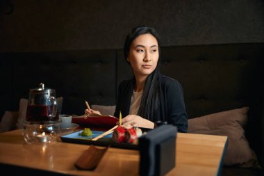 Düşünceli kadın yazar, en sevdiği restoranda lezzetli suşi setini yiyip, çay içerek zaman geçiriyor. Gelecek kitabına notlar aldığı için kendisine ilham veriyor.