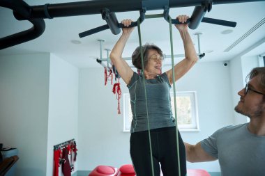 Rehabilitolog, uzaklaştırma sistemi üzerine dersler veriyor. Yaşlı bir kadınla çalışıyor.