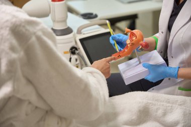 Doktor, rahmin duvarlarını tedavi etmeden önce jinekologla görüşüyor. Rahmin bir kopyasını kullanıyor.