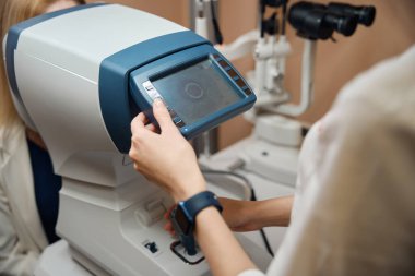 İş yerindeki kadın göz doktoru özel modern ekipmanlar kullanıyor.