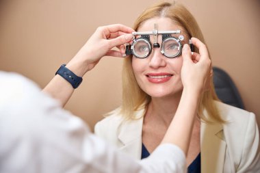 Oftalmolog bir hasta için lens seçer, doktor özel deney lensleri kullanır.