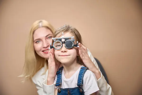 stock image Child with his mother at an appointment with an ophthalmologist, a girl is being fitted with trial lenses