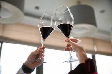 Romantik bir çiftin restoranda kadeh tokuşturup kadeh tokuştururken çekilmiş bir fotoğrafı. Romantizm, tarih, ilişki kavramı