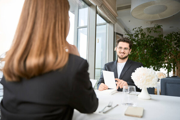 Романтичный мужчина и женщина сидят за столом в ресторане и обедают. Романтика, дата, концепция отношений