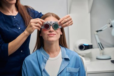 Kafkas doktoru vizyon muayenesi sırasında genç bir hastanın yüzünü dikkatlice düzeltir.