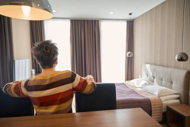 Yetişkin bir kadının otel odasında poz verişi. Seyahat kavramı