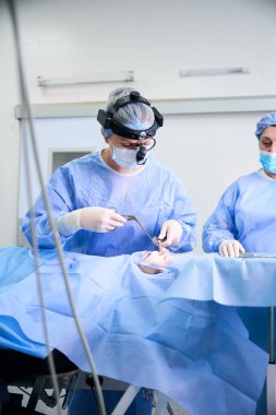 Cerrah, yakın çevrede deneyimli bir asistanla burun boşluğunun düzeltilmesi için ameliyat yapar.