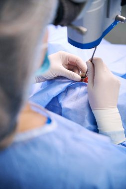 Özel optik ekipmanlar kullanarak ameliyathanede deneyimli bir cerrah.